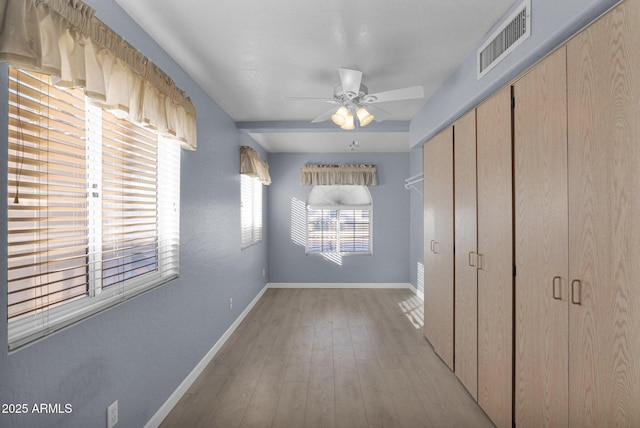 unfurnished bedroom with ceiling fan, a closet, and light wood-type flooring