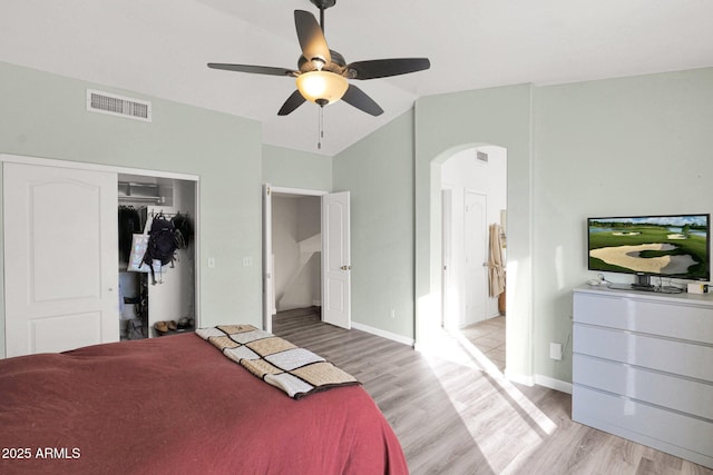 bedroom with light wood-type flooring, ceiling fan, a closet, and vaulted ceiling