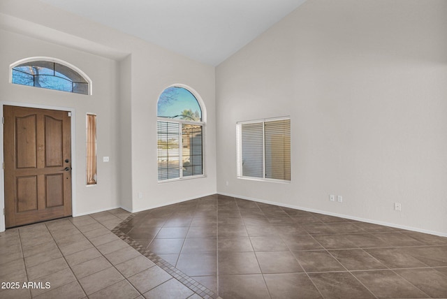 tiled foyer featuring high vaulted ceiling