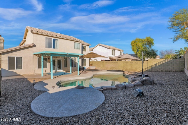 back of house with a fenced in pool and a patio