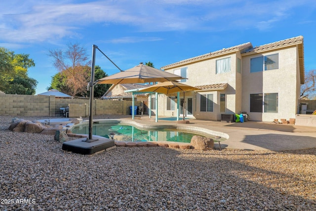 rear view of house with a patio and a fenced in pool