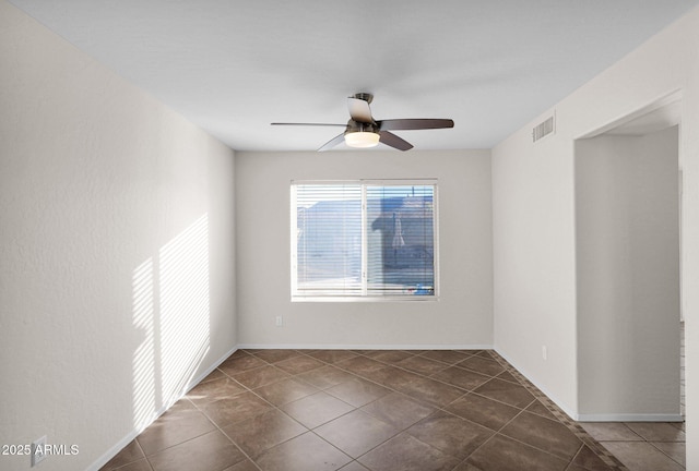 tiled empty room featuring ceiling fan