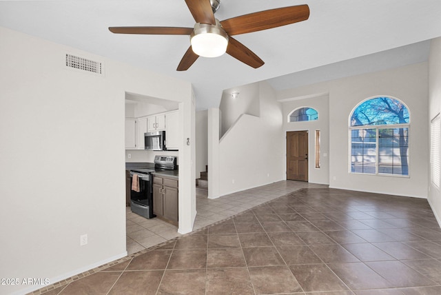 unfurnished living room featuring ceiling fan and tile patterned floors