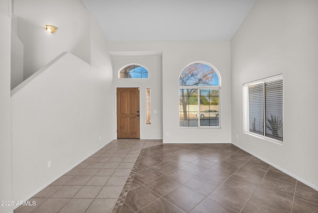 entryway featuring a high ceiling and dark tile patterned flooring