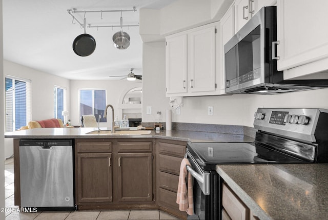 kitchen with ceiling fan, sink, light tile patterned floors, stainless steel appliances, and white cabinets