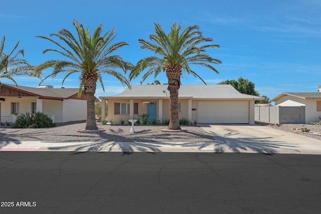 single story home with a garage, stucco siding, driveway, and fence