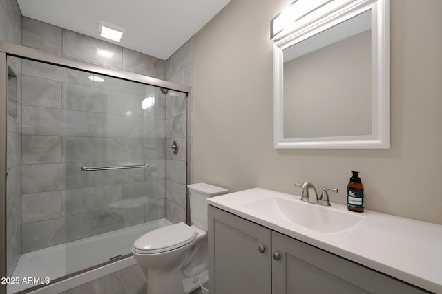 full bathroom with tiled shower, toilet, and vanity