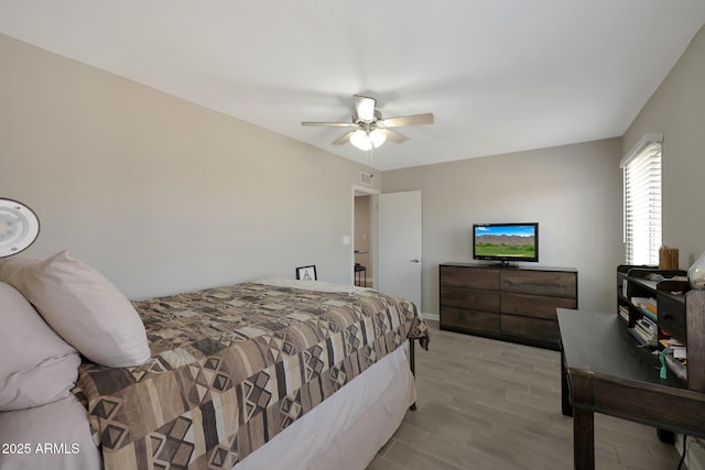 bedroom with visible vents, light wood-style flooring, and a ceiling fan