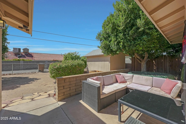 view of patio featuring an outbuilding, outdoor lounge area, and a fenced backyard