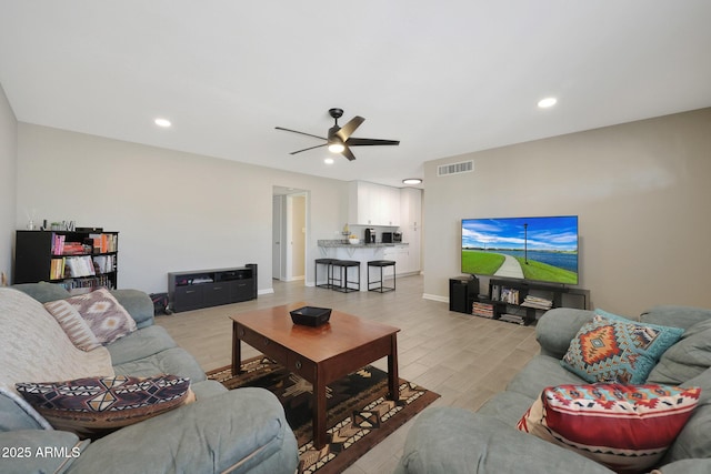 living room with a ceiling fan, light wood-style flooring, recessed lighting, and visible vents