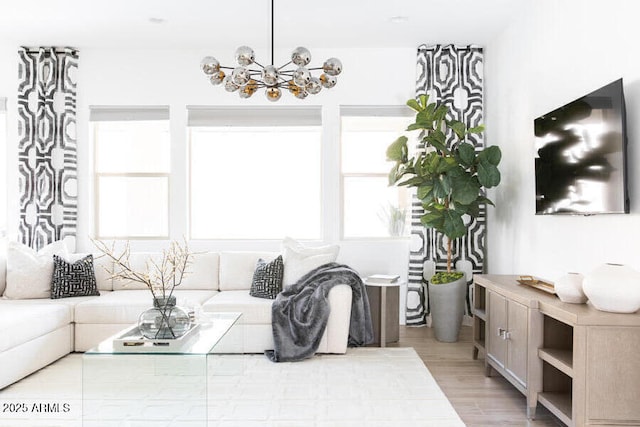 living room with a chandelier and light wood-type flooring