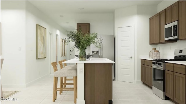 5064 S 234th Ave, Buckeye, AZ 85326 - kitchen featuring stainless steel appliances, light tile patterned floors, light countertops, and a breakfast bar area