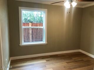 unfurnished room featuring crown molding, wood-type flooring, and ceiling fan