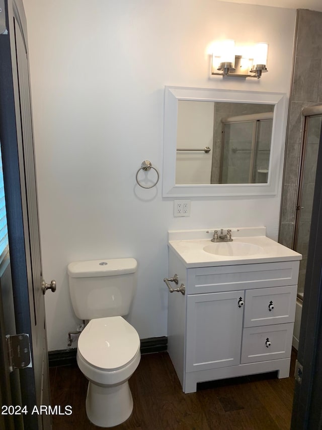 bathroom with oversized vanity, toilet, and hardwood / wood-style flooring