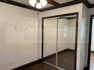 unfurnished bedroom featuring a closet, ceiling fan, hardwood / wood-style flooring, and ornamental molding