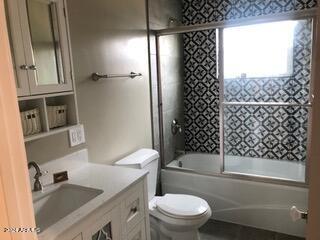 full bathroom featuring vanity, toilet, and bath / shower combo with glass door