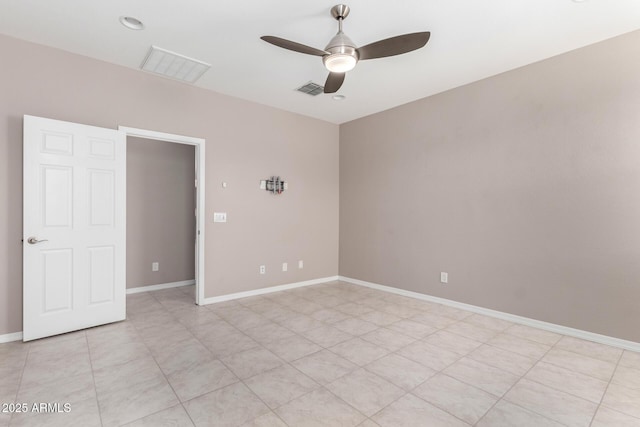 spare room featuring baseboards, visible vents, and ceiling fan