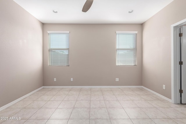 spare room with baseboards, a healthy amount of sunlight, and a ceiling fan