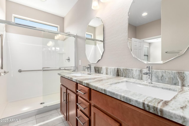 full bath with double vanity, a sink, tile patterned floors, and a shower stall