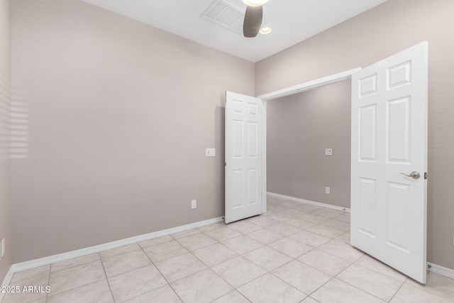 spare room with baseboards, light tile patterned flooring, and a ceiling fan
