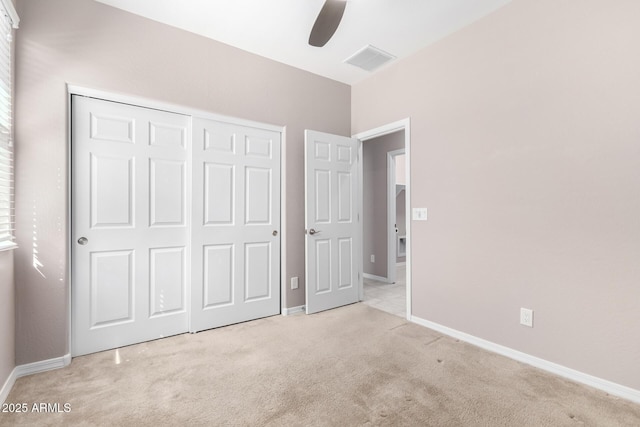 unfurnished bedroom featuring light carpet, baseboards, a closet, and visible vents