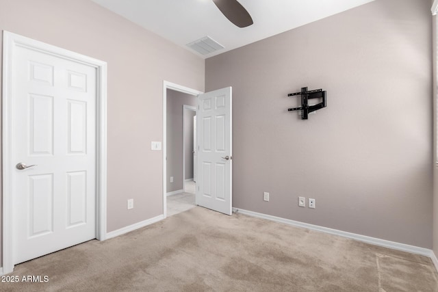 unfurnished bedroom featuring light colored carpet, visible vents, ceiling fan, and baseboards