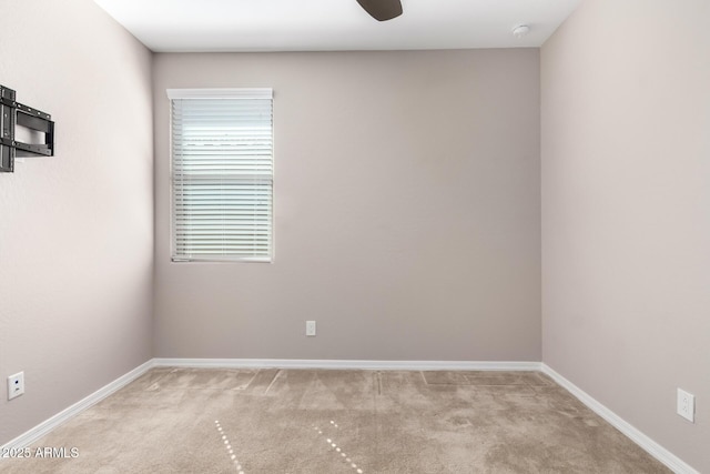 empty room featuring light carpet and baseboards