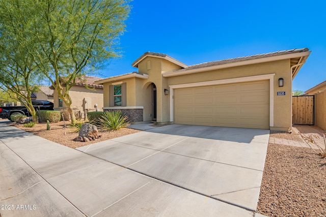 view of front of home featuring stucco siding, a tile roof, concrete driveway, and an attached garage