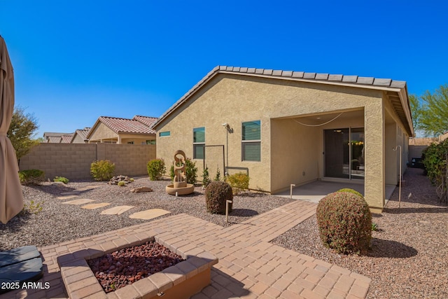 back of property featuring a fenced backyard, stucco siding, and a patio area