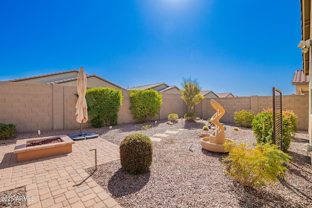 view of yard featuring a fenced backyard, an outdoor fire pit, and a patio area