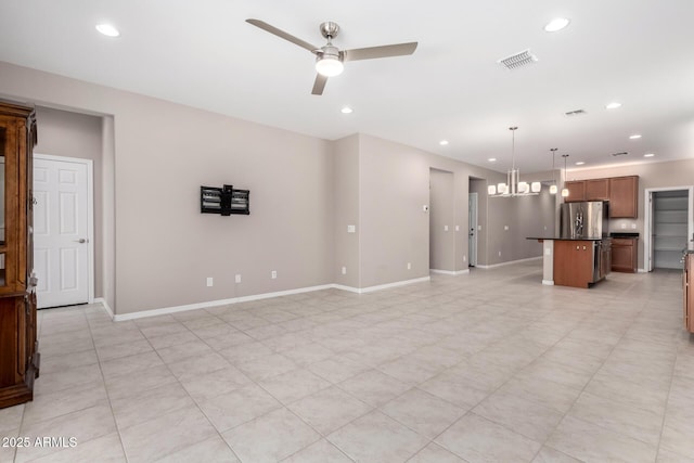 unfurnished living room featuring recessed lighting, ceiling fan with notable chandelier, baseboards, and visible vents