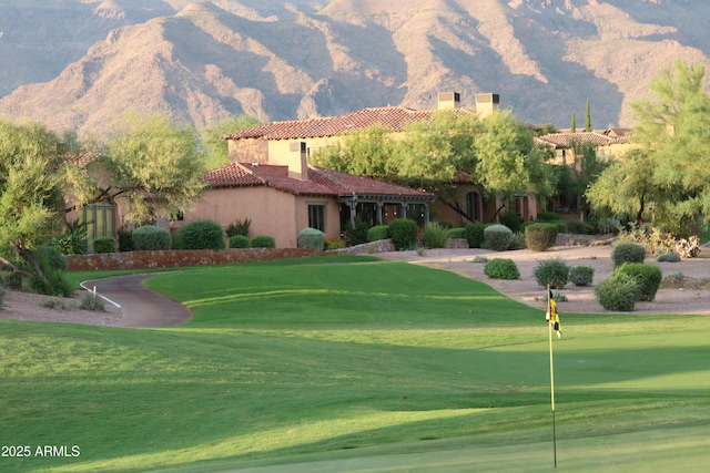 surrounding community with a mountain view and a yard