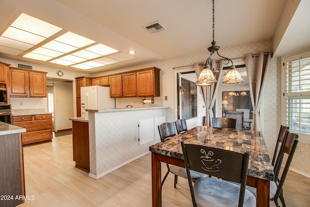 kitchen featuring a chandelier, light wood-type flooring, hanging light fixtures, and appliances with stainless steel finishes