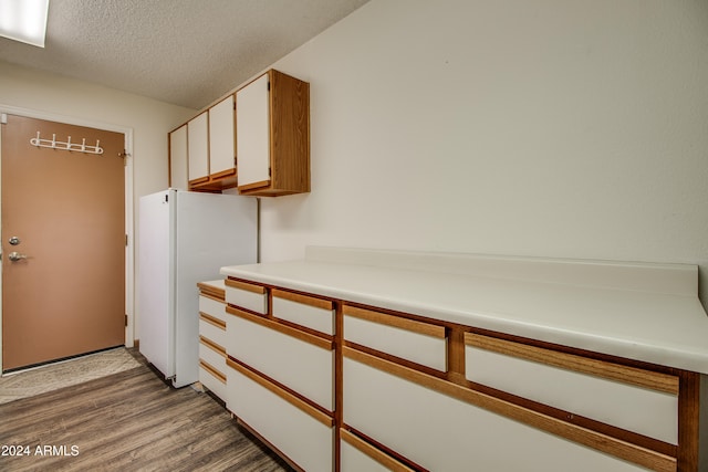 hall featuring hardwood / wood-style floors and a textured ceiling