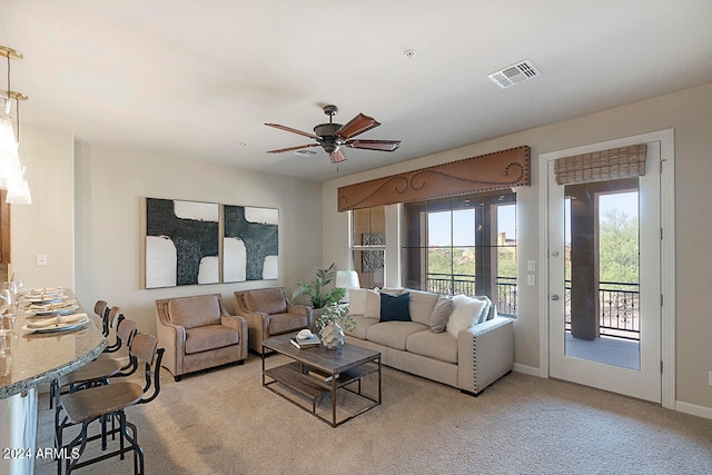 carpeted living room with ceiling fan