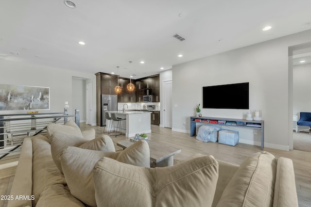 living room with light hardwood / wood-style floors and sink