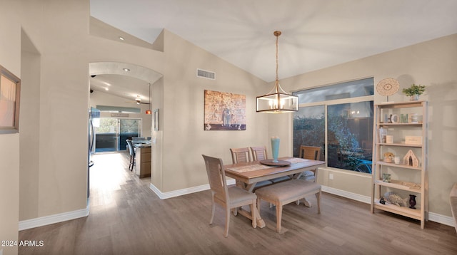 dining area featuring wood-type flooring and vaulted ceiling