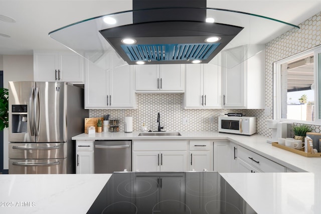 kitchen featuring stainless steel appliances, a sink, white cabinetry, and tasteful backsplash
