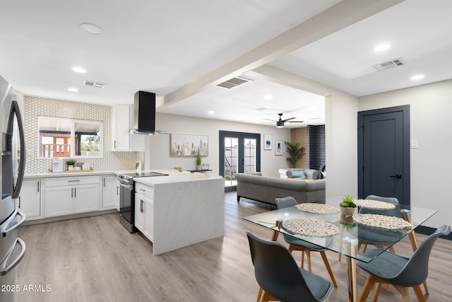 kitchen with range hood, stainless steel appliances, a peninsula, a ceiling fan, and white cabinets