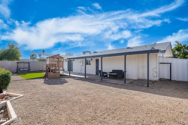 back of property with a playground, a patio, and fence