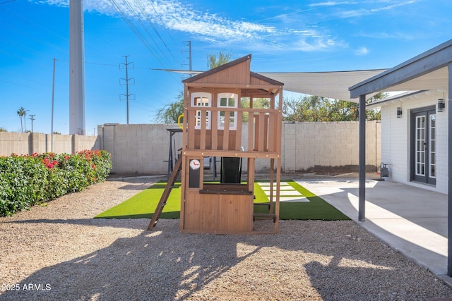 view of jungle gym featuring a fenced backyard and a patio area