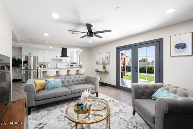 living area with french doors, recessed lighting, light wood-style flooring, and ceiling fan