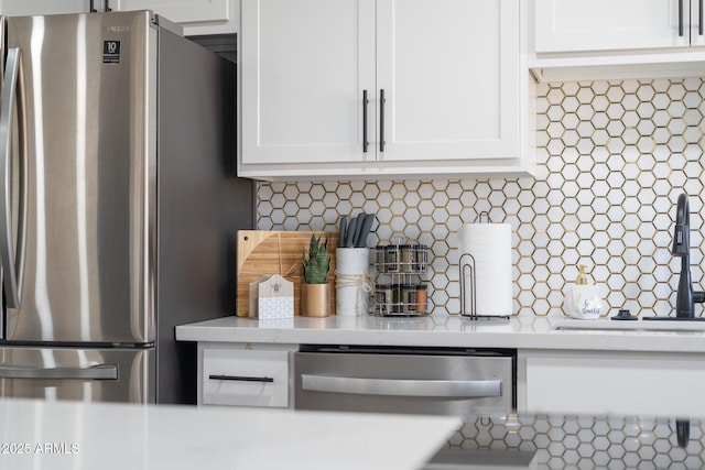 kitchen featuring appliances with stainless steel finishes, light countertops, and white cabinets