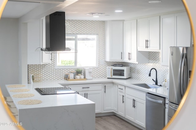 kitchen featuring appliances with stainless steel finishes, a sink, extractor fan, a peninsula, and white cabinets