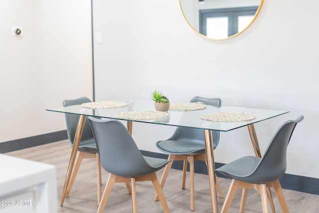 dining room featuring light wood-style flooring and baseboards