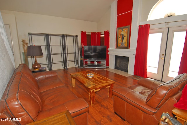 living room featuring hardwood / wood-style flooring, lofted ceiling, and french doors