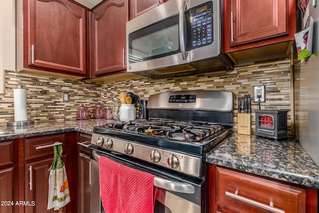 kitchen with decorative backsplash, stainless steel appliances, and dark stone countertops