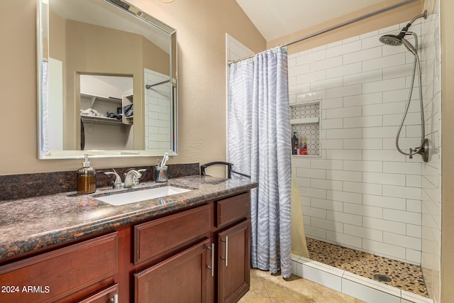 bathroom featuring a shower with curtain, vanity, vaulted ceiling, and tile patterned flooring