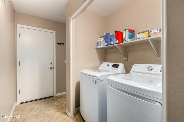 washroom featuring washer and clothes dryer and light tile patterned floors