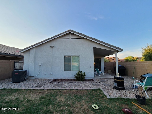 rear view of property featuring a patio, central AC unit, and a yard